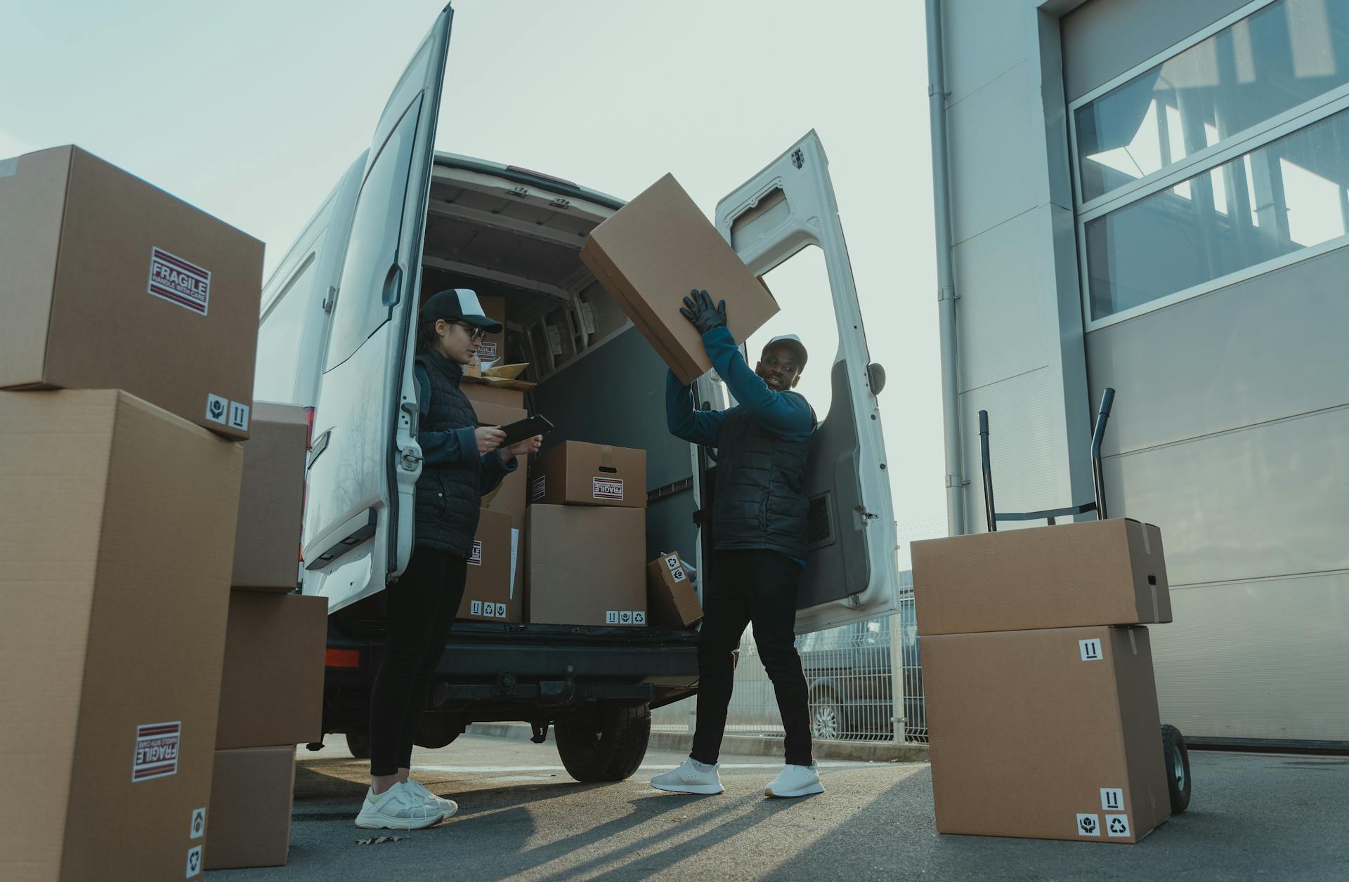 Moving crew loading cardboard boxes into a moving van